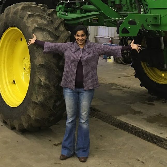 Aneetha Gopalan, VP of Engineering & Product in front of a John Deere tractor