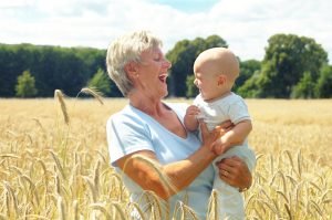 Grandmother with a grandchild standing in a wheat field