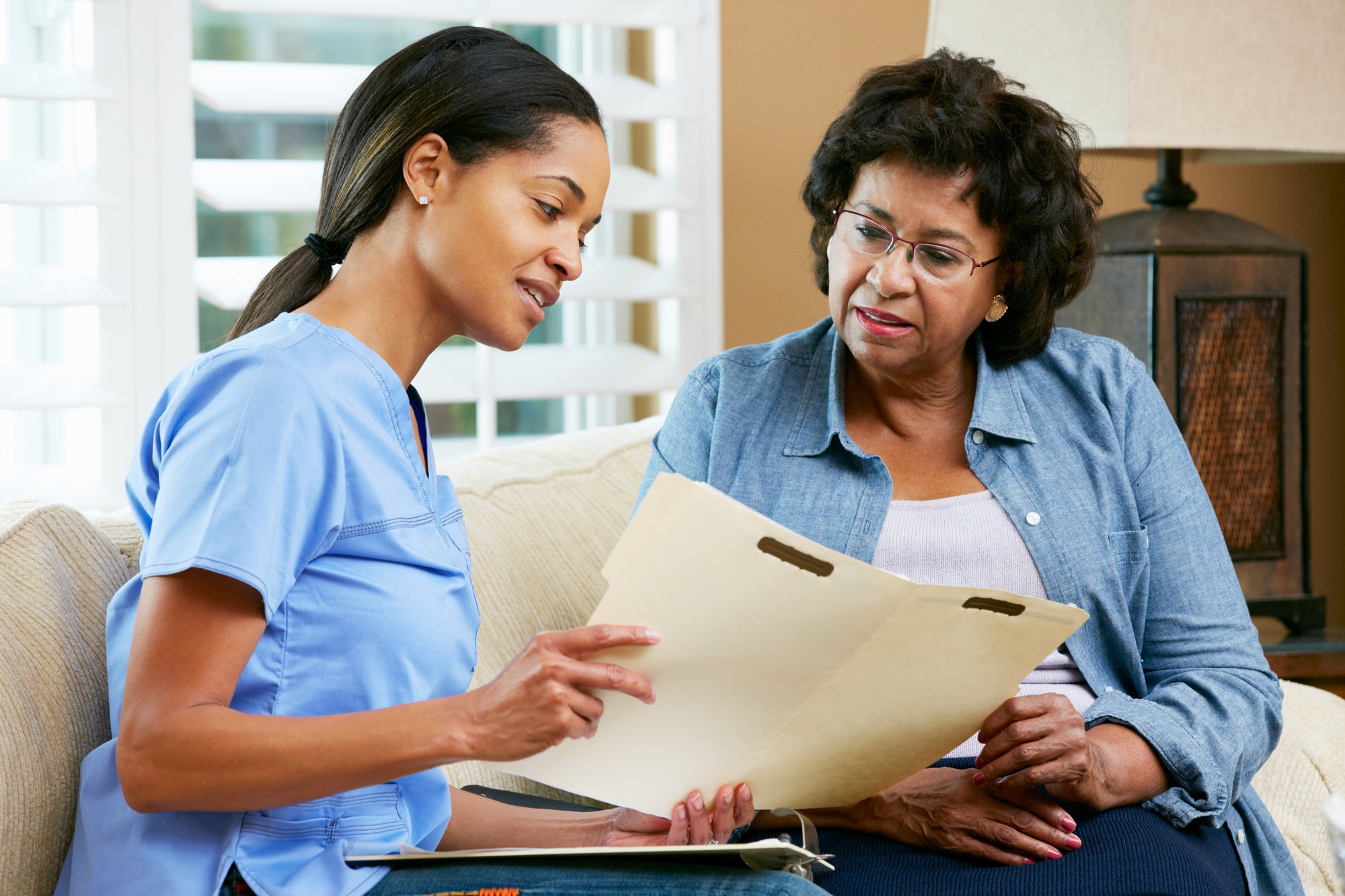 Doctor discussing records with senior Female patient in a healthcare setting