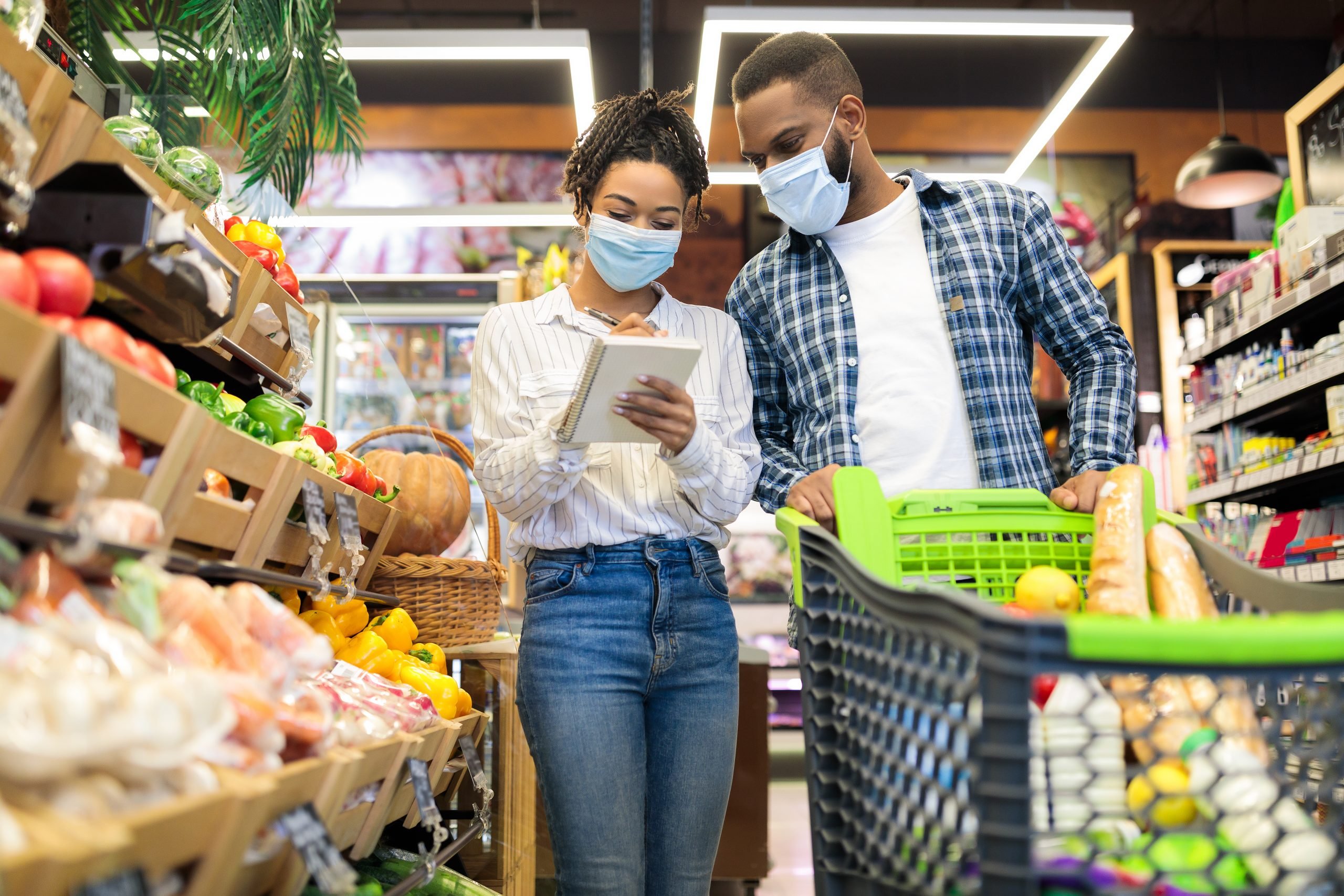 Couple buying food with shopping cart in grocery store